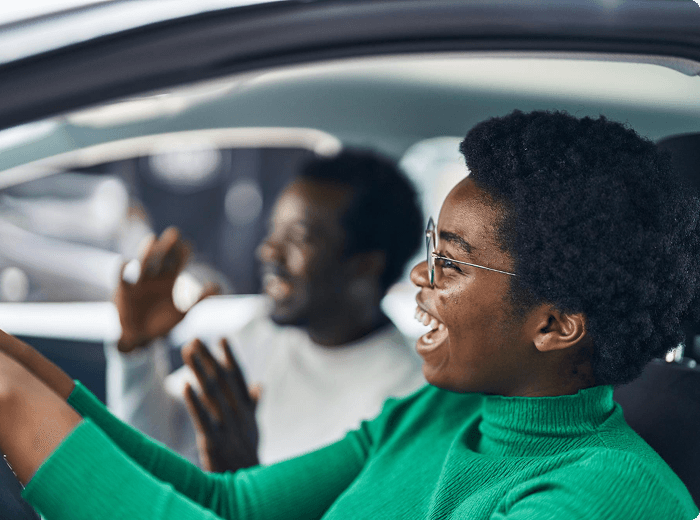 Driver and passenger talking in a car.